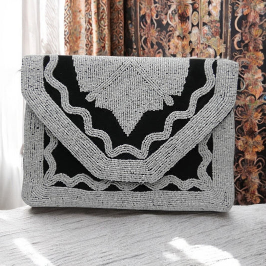 Black clutch bag with white beading with a detachable cross body chain