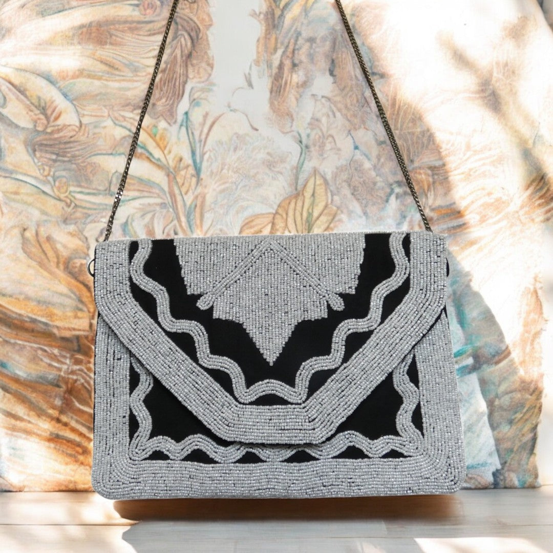 Black clutch bag with white beading with a detachable cross body chain