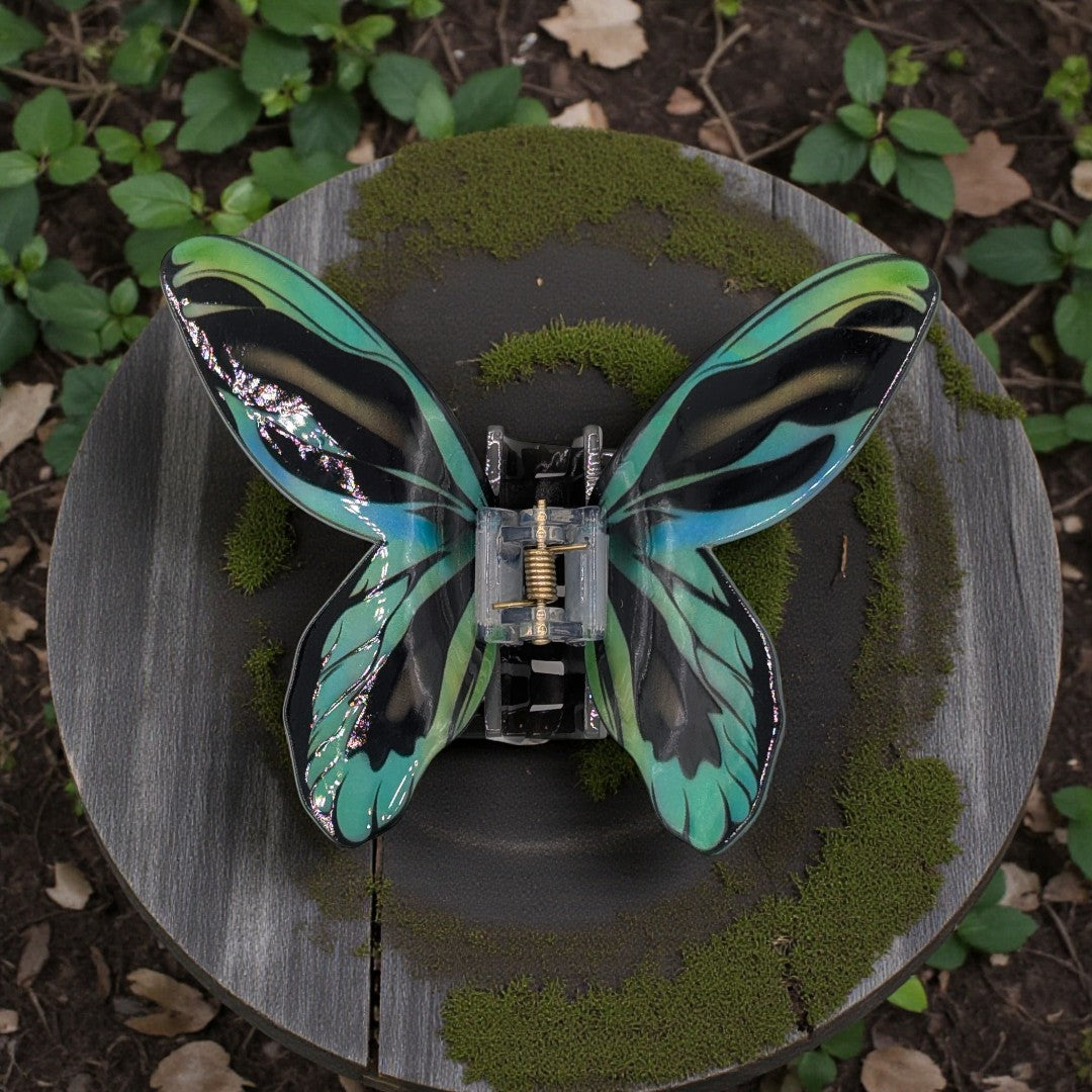 a butterfly hair claw clip in black, green and blue