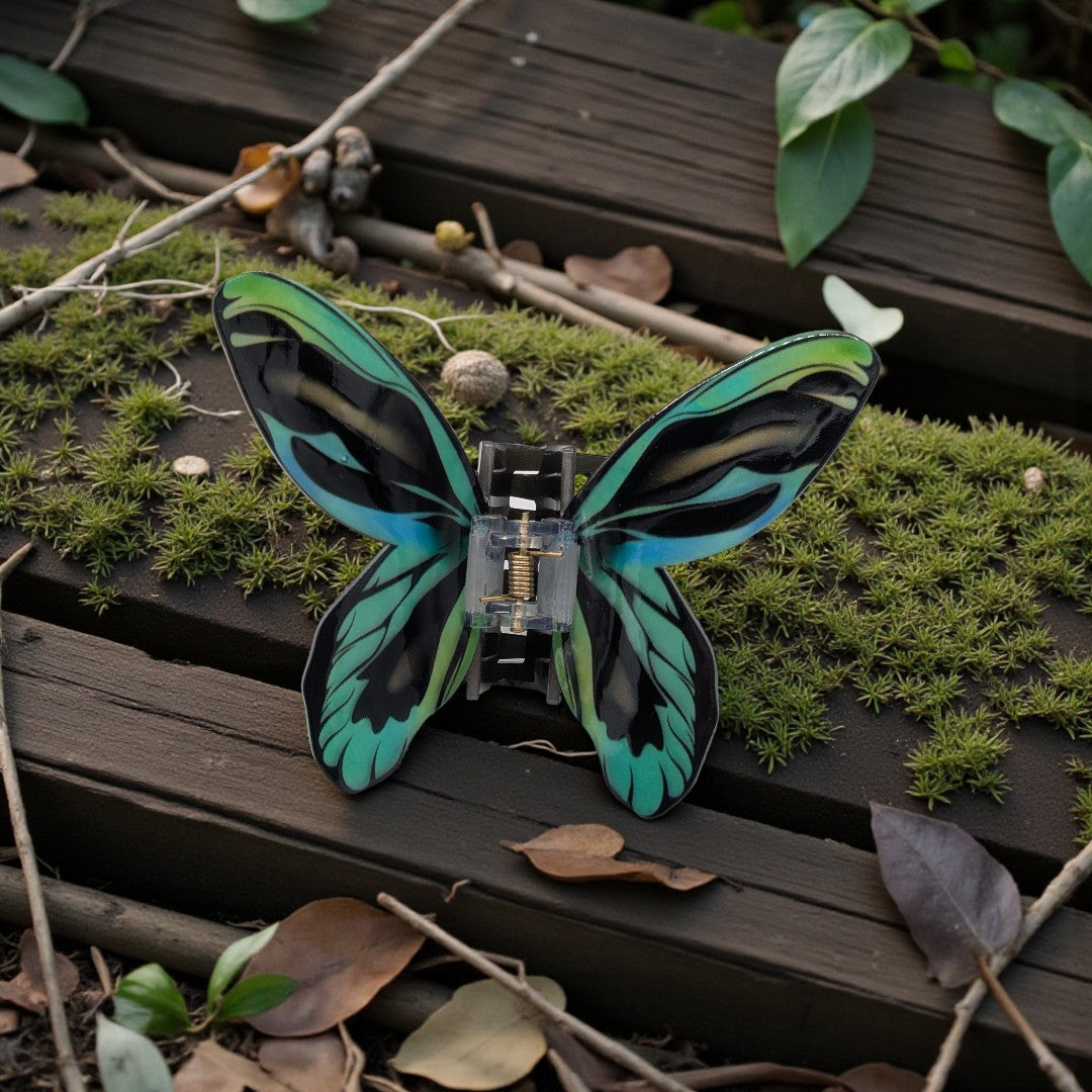 A butterfly hair clip in black, blue and green