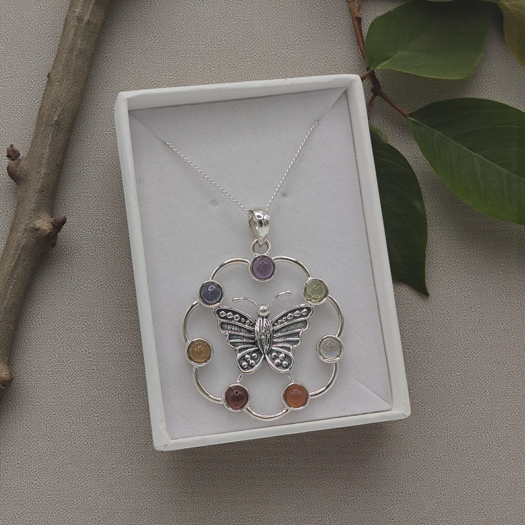 A sterling silver butterly necklace with chakra gemstones on an 18 inch chain