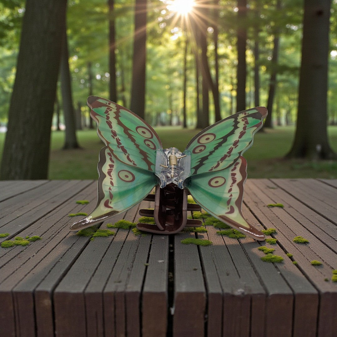 A luna moth hair claw clip in green and brown
