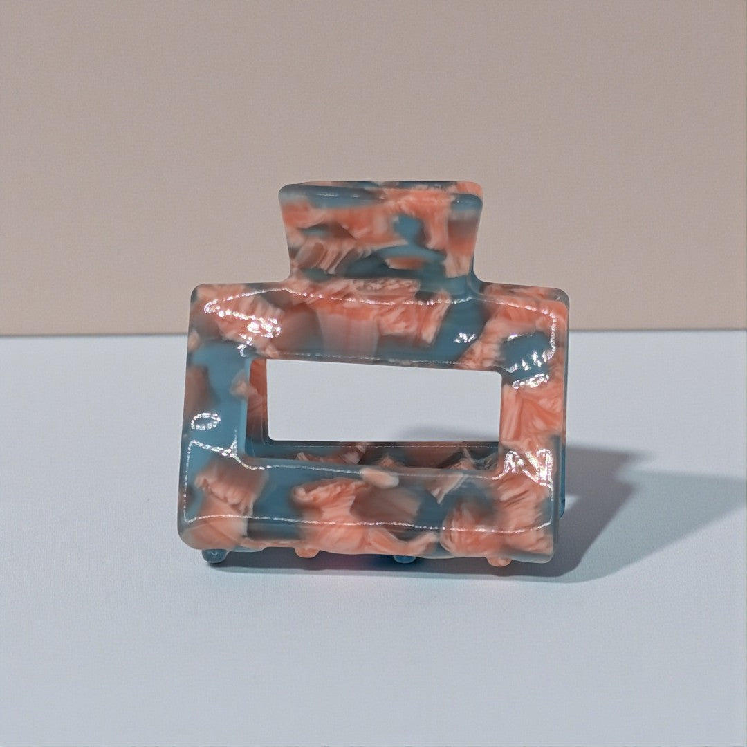 A small hair claw clip in pink and blue