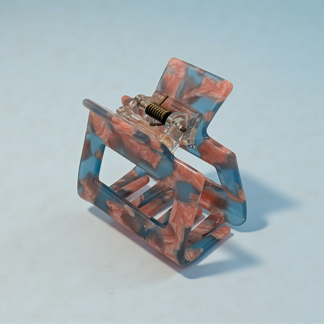 A small hair claw clip in pink and blue